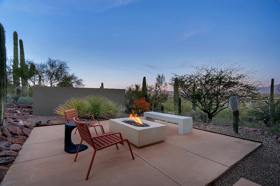 Fire pit lounge at dusk overlooking the desert as the sky shifts from blue to stars.