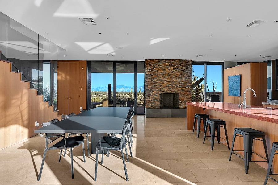 Open living and dining area with floor-to-ceiling glass and expansive desert views.