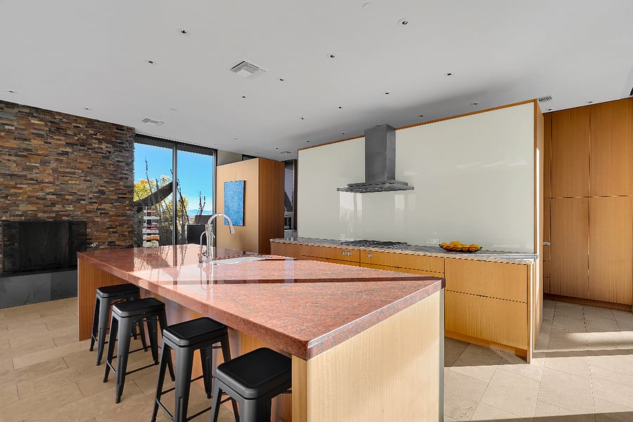 Chefs kitchen with oversized island, seating, and seamless indoor-outdoor flow.