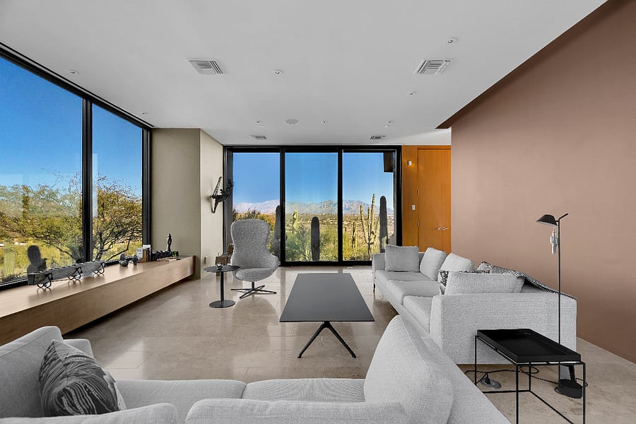 Main living room with panoramic glass walls and unobstructed mountain vistas.