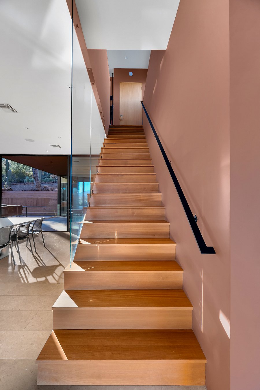 Architectural stairway with floating wood treads and glass balustrade.
