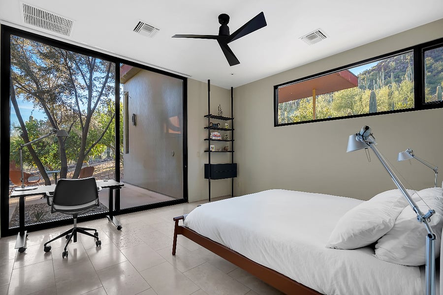 Serene first floor guest bedroom with floor-to-ceiling glass, minimalist design, and direct outdoor access.