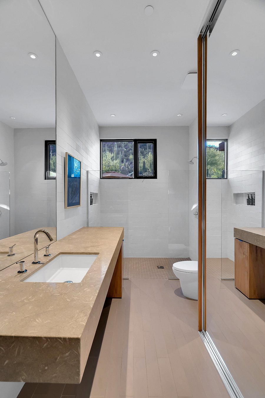 Bright guest ensuite with walk-in shower, large mirror, and natural desert light.