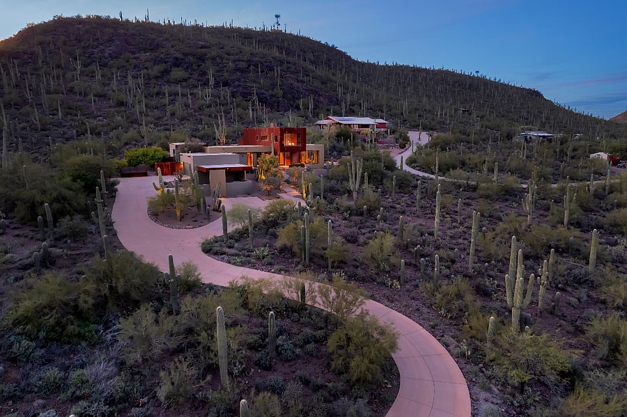Twilight aerial view showing the home set on over three private acres, surrounded by untouched Sonoran Desert.