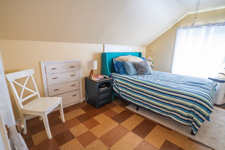 Upstairs, west bedroom with window A/C unit and ceiling fan.