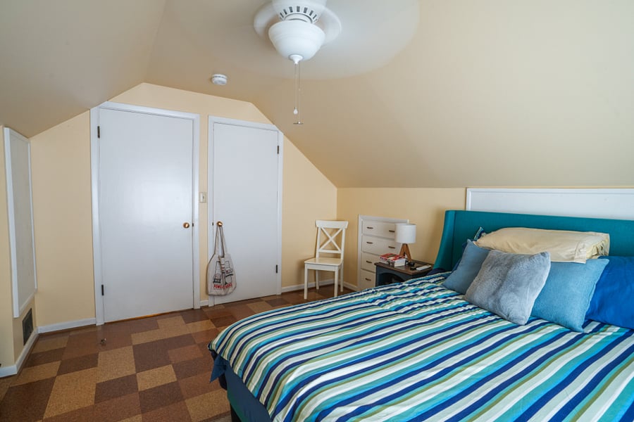 Upstairs, west bedroom with window A/C unit and ceiling fan.