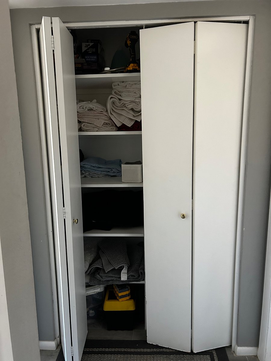 Hall closet with storage, towels washcloths, board games, umbrellas and extra hangers. 