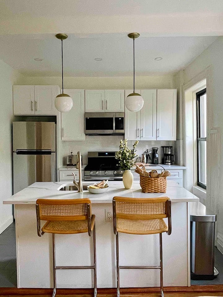 The kitchen is well stocked with a dishwasher, serving ware, pots, pans, multiple types of coffee makers, kitchen towels
