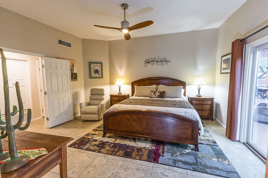 Master bedroom with King bed, TV, overhead fan, recliner chair