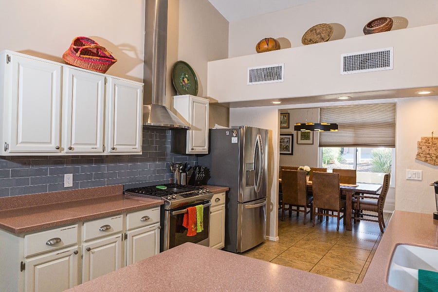 Kitchen with full fridge and ice maker opens out to large dining room table