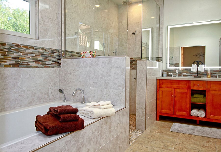 Master bathroom soaking tub and walk in shower with rainhead, regular wall fixture and handheld available. Shower has foldable bench and shampoo cubby
