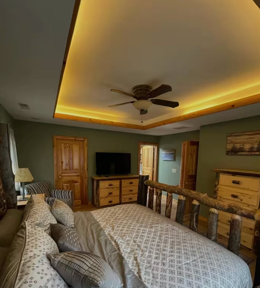 Primary bedroom with a king-sizeGuest bedroom with queen bed and rustic finishes log bed, smart TV, and walk-in closet.