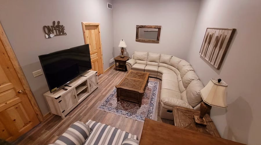 Lower-level family room with a large sectional and smart TV.