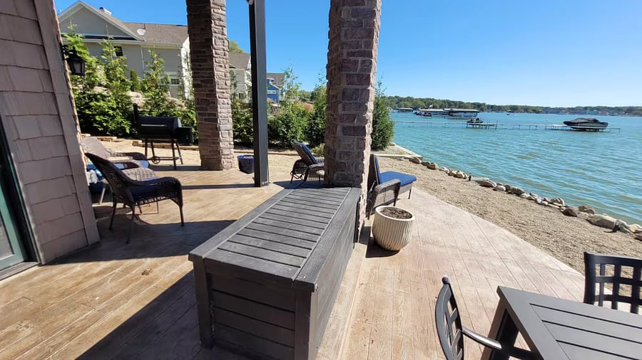 Lakefront patio with outdoor dining and grill.