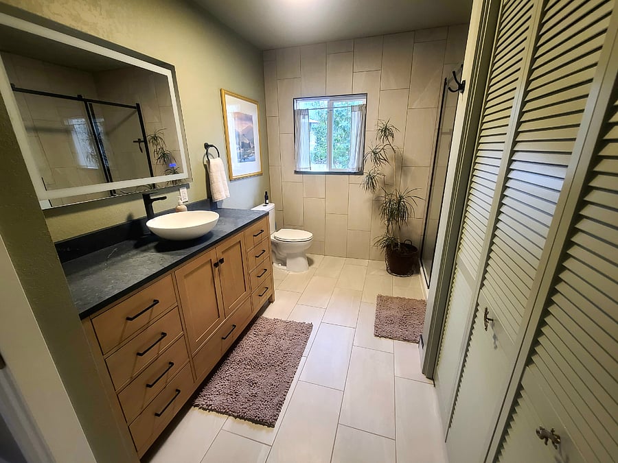 Bathroom features lighted anti-fog mirror and laundry.