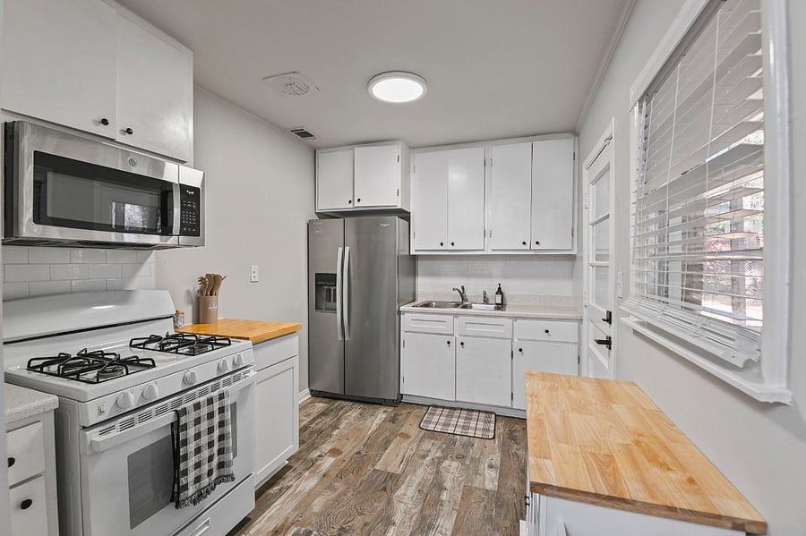 Fully equipped kitchen with stainless steel appliances, including a gas range and full-sized refrigerator.