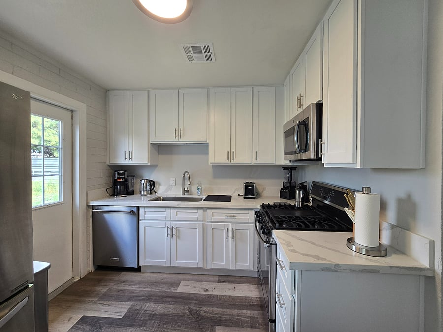 Fully stocked kitchen with cookware and coffee maker. 