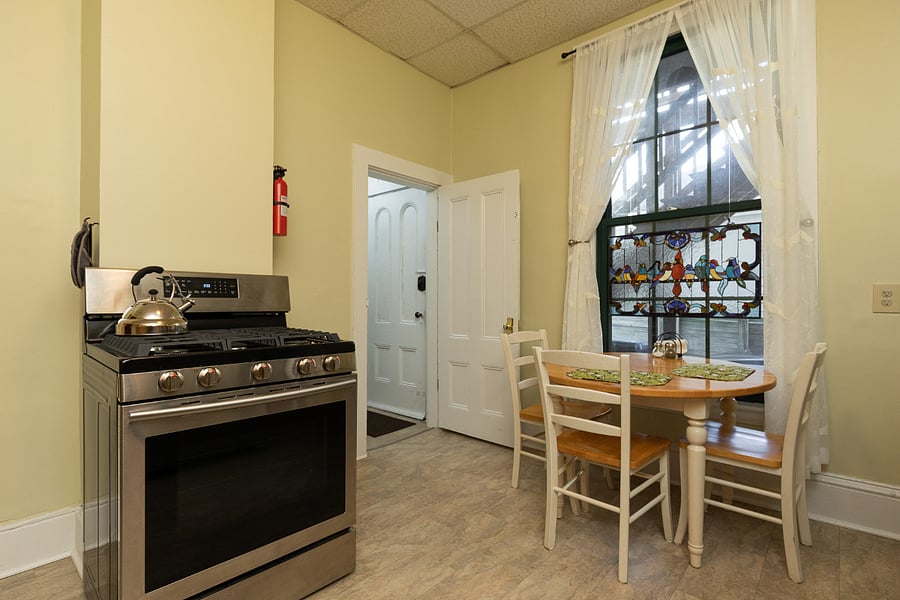 Rest of kitchen, with gas stove, showing private entry door to shared back yard garden.