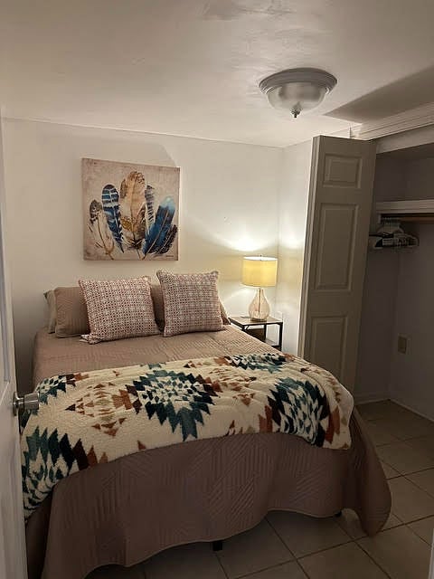 Bedroom with large hanging and a closet with all shelves.