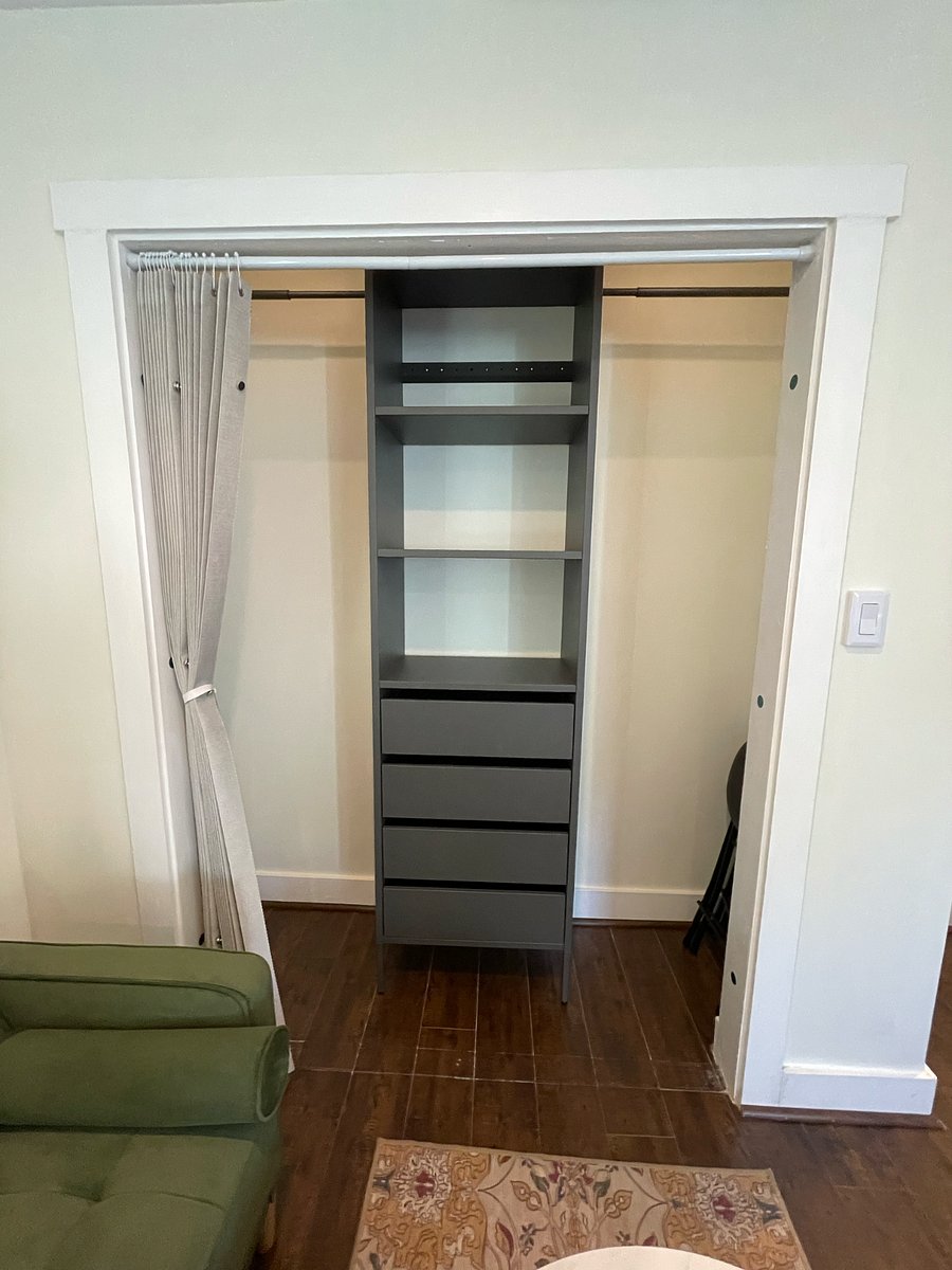 Custom closet with hanging space, shelves, and drawers. Curtains for privacy.