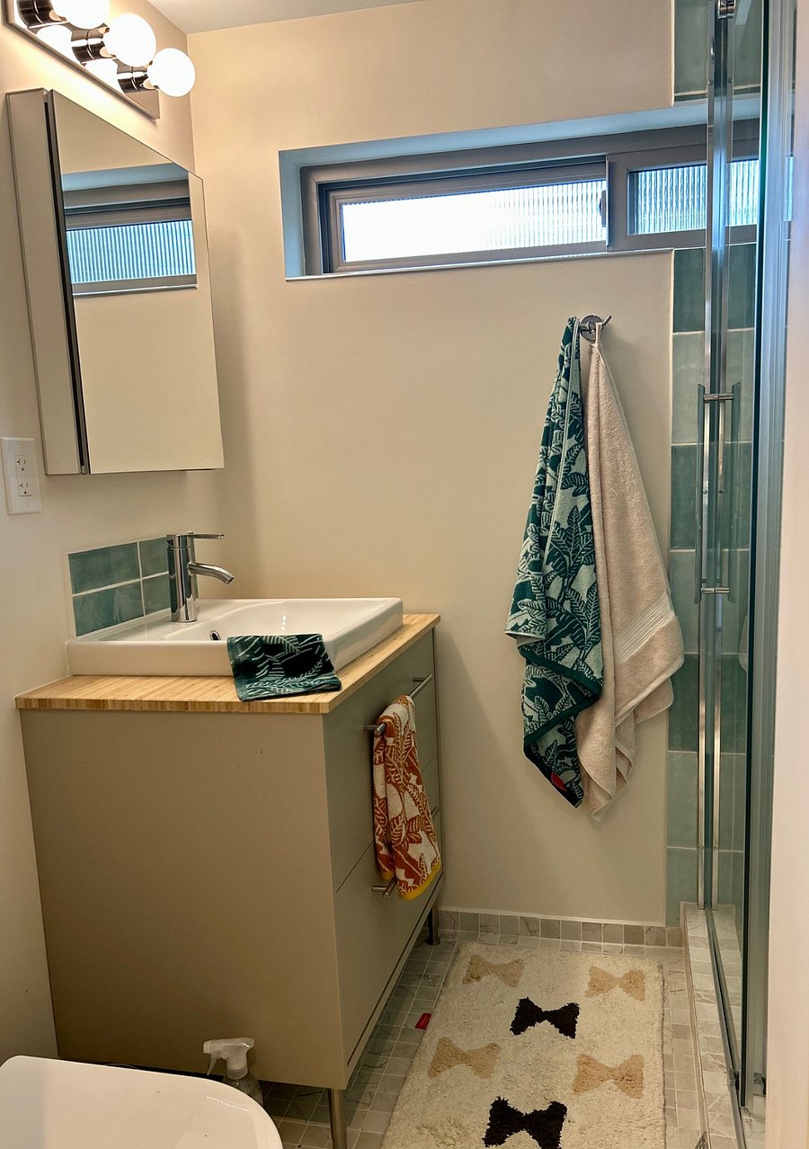 Captivating aqua accented bath has spacious spa like shower and extraordinary storage.