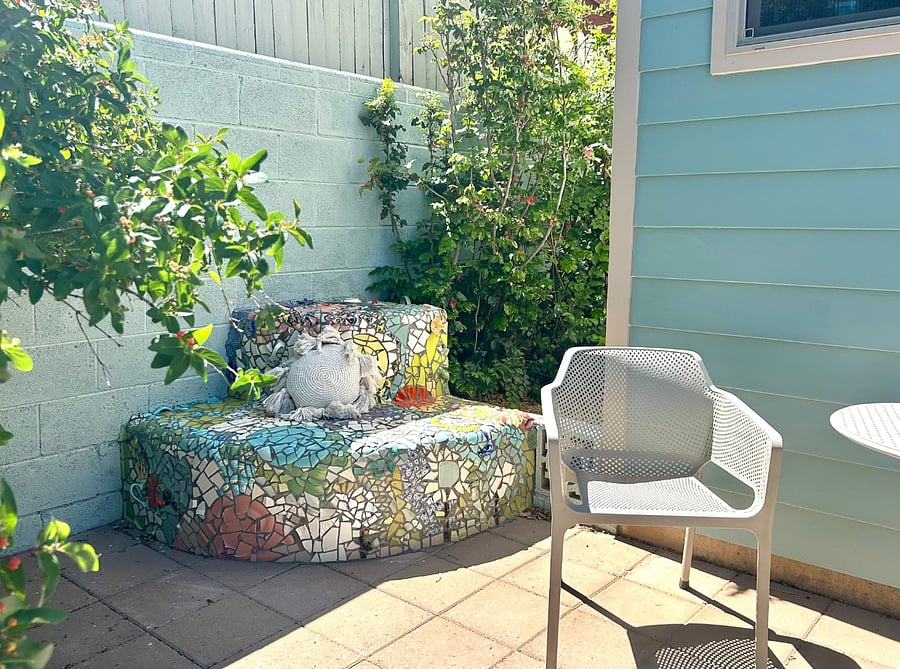 Two patios surrounded by lush greenery make the tiny house feel more spacious, relaxing, and inviting.