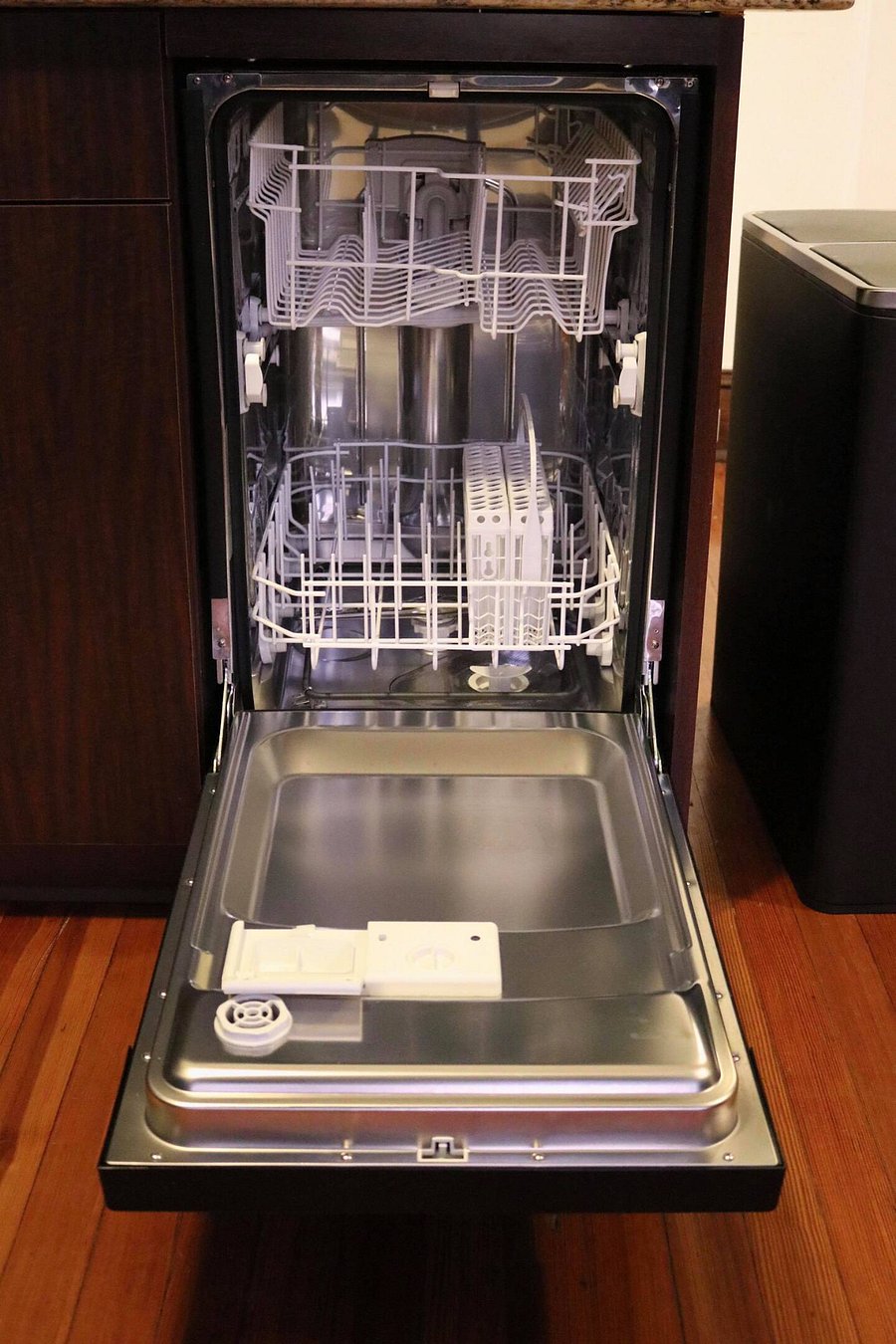 An apartment sized dishwasher sits to the right of the kitchen sink.
