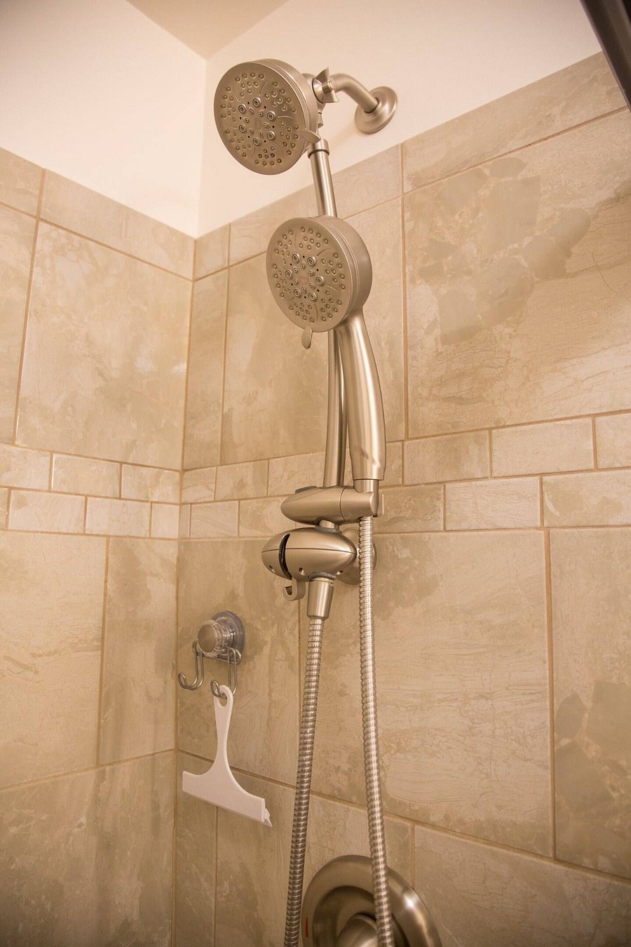 The dual shower heads can be used simultaneously and/or independently. The one fixed at the top can swivel and the wand can be held and/or slide up/down.
