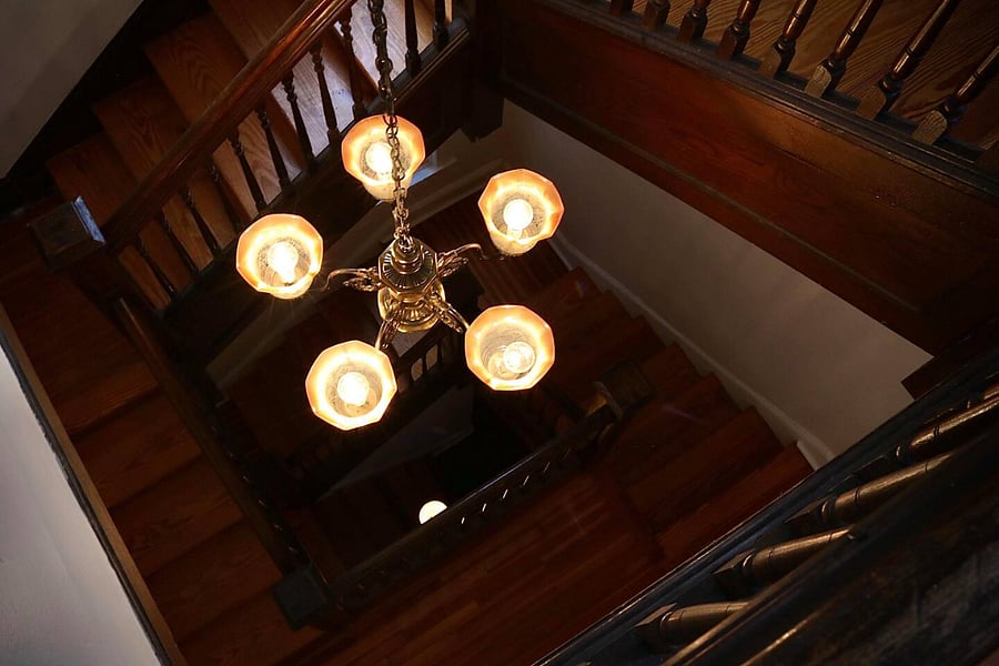 The view of the staircase from the apartment door, with the chandelier you can turn on/off at all landings & the sconce that is always on at the bottom