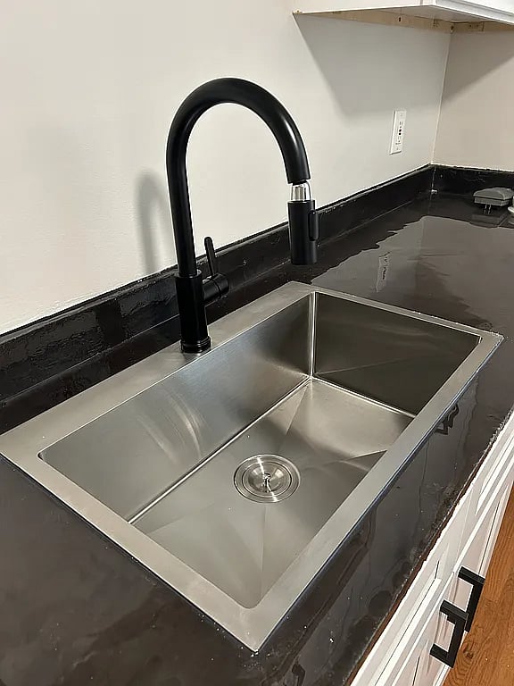 Sleek kitchen sink with dishwasher and garbage disposal, making cleanup fast and easy for stress-free cooking.