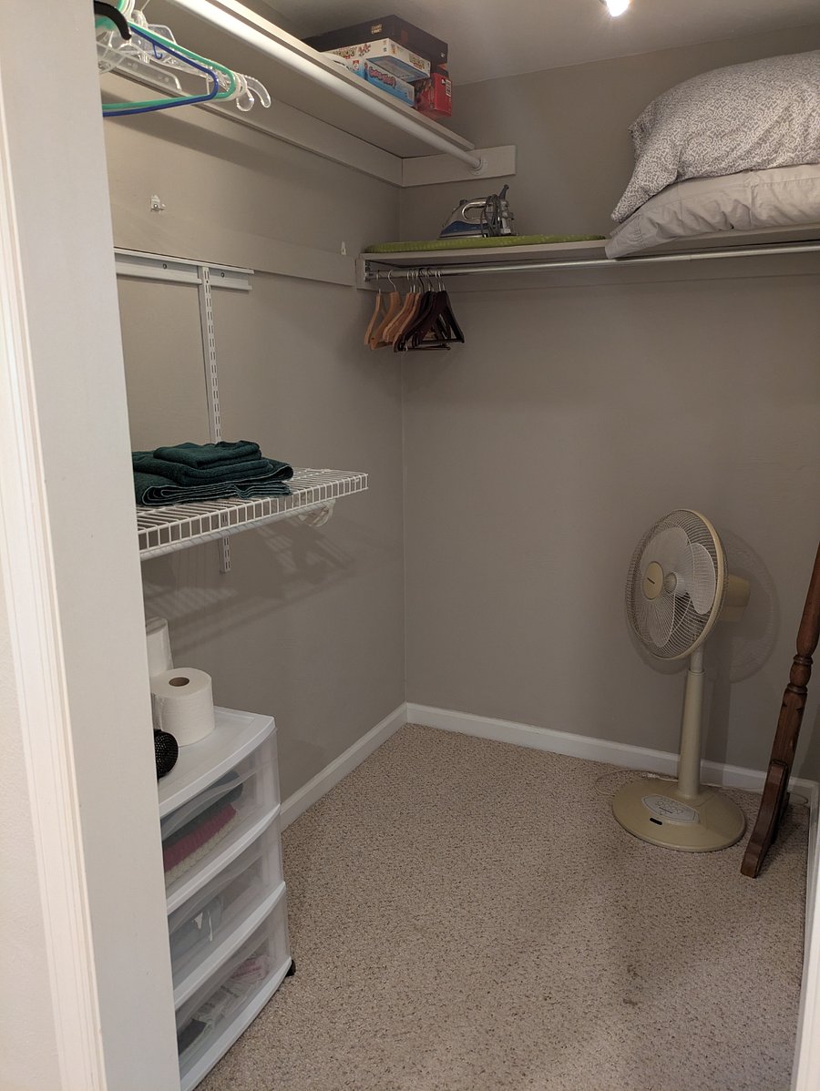 3rd Fl walk in closet with portable fan, board games, hair dryer, iron/ironing board