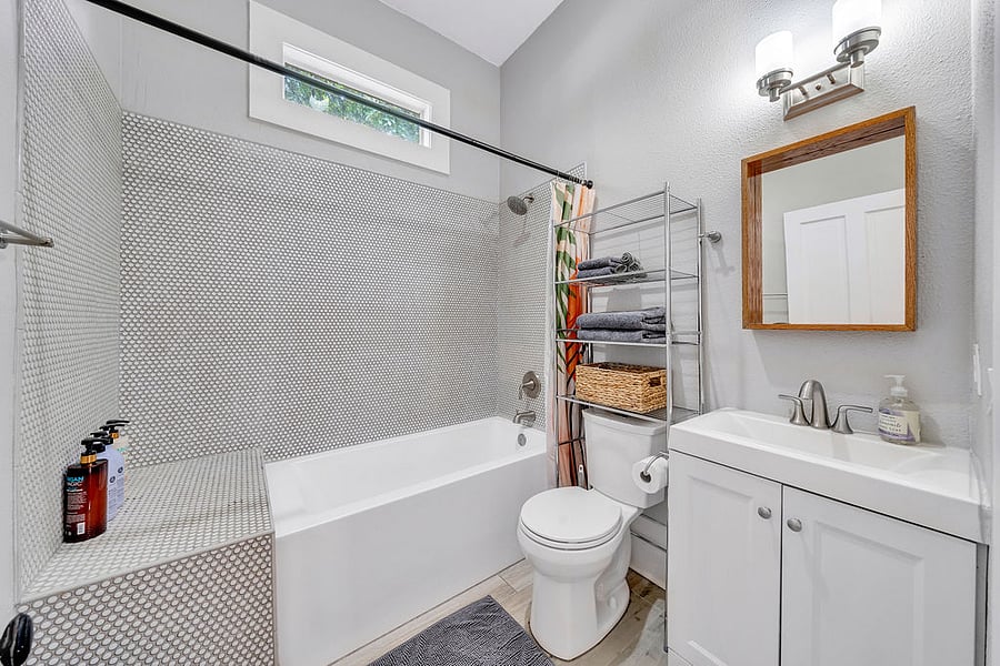 The bathroom features a deep tub that is great for soaking acter a long day.