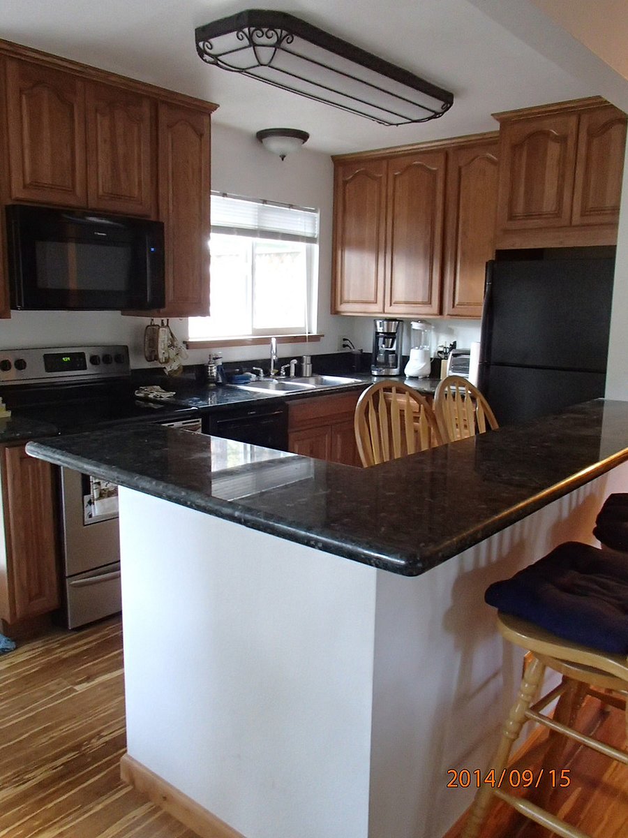Kitchen with maple cabinets and marble countertops. In addition to the pub table, you can dine at the passthrough counter.