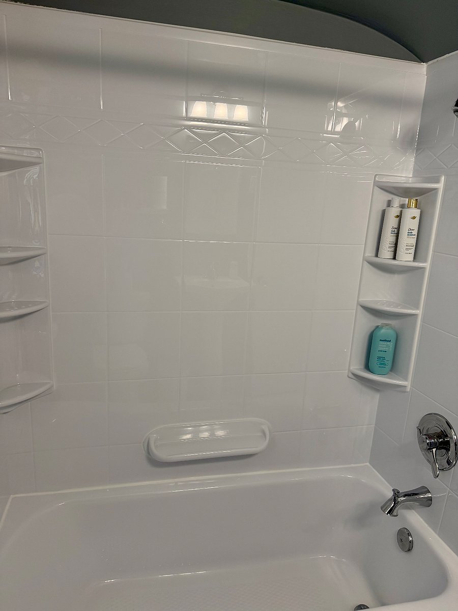 Bathtub/shower by Bathfitter- lots of shelf storage for products.
