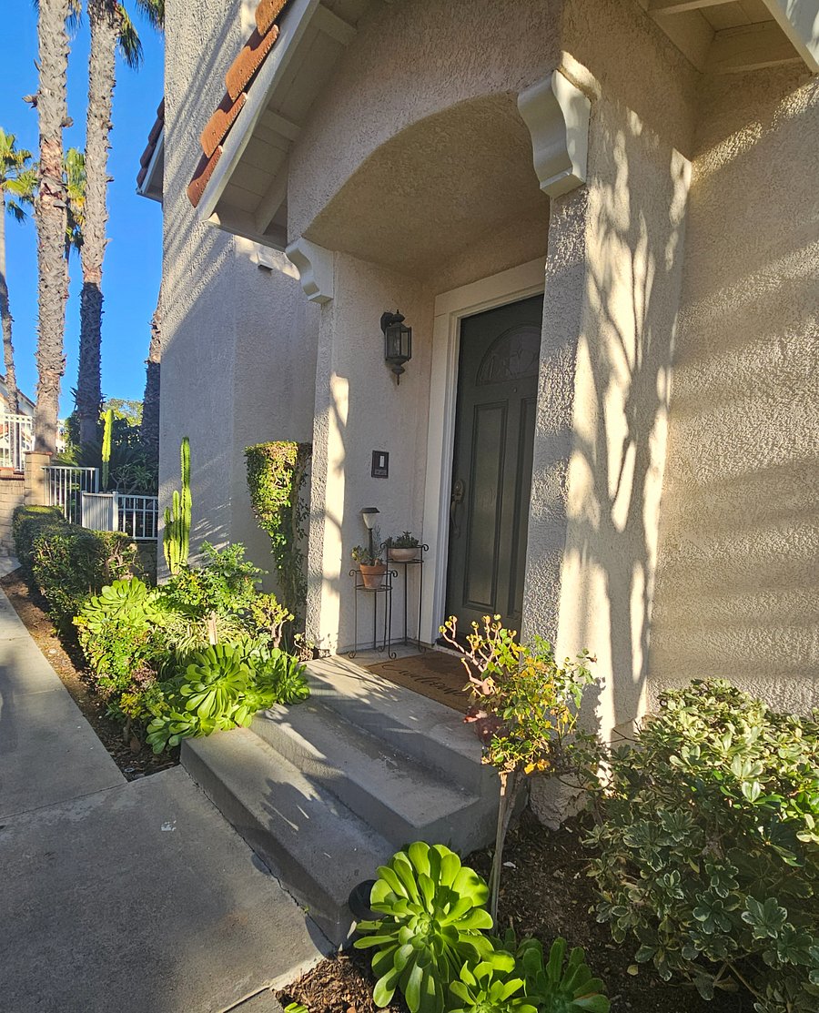 Home has a patio with table, chairs and umbrella.