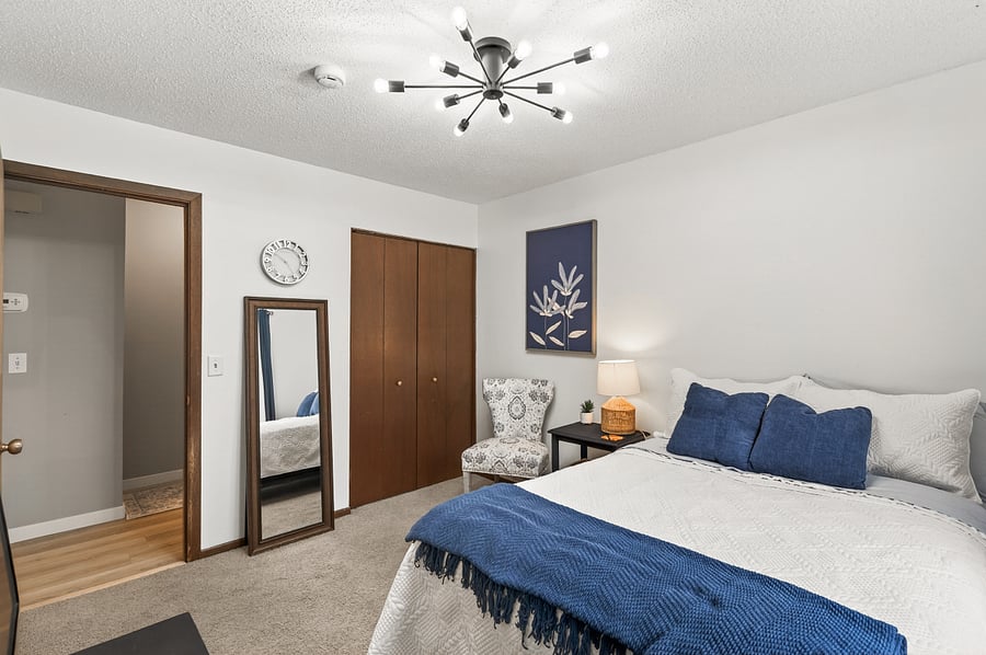 Second bedroom upstairs with a dresser and medium sized closet.