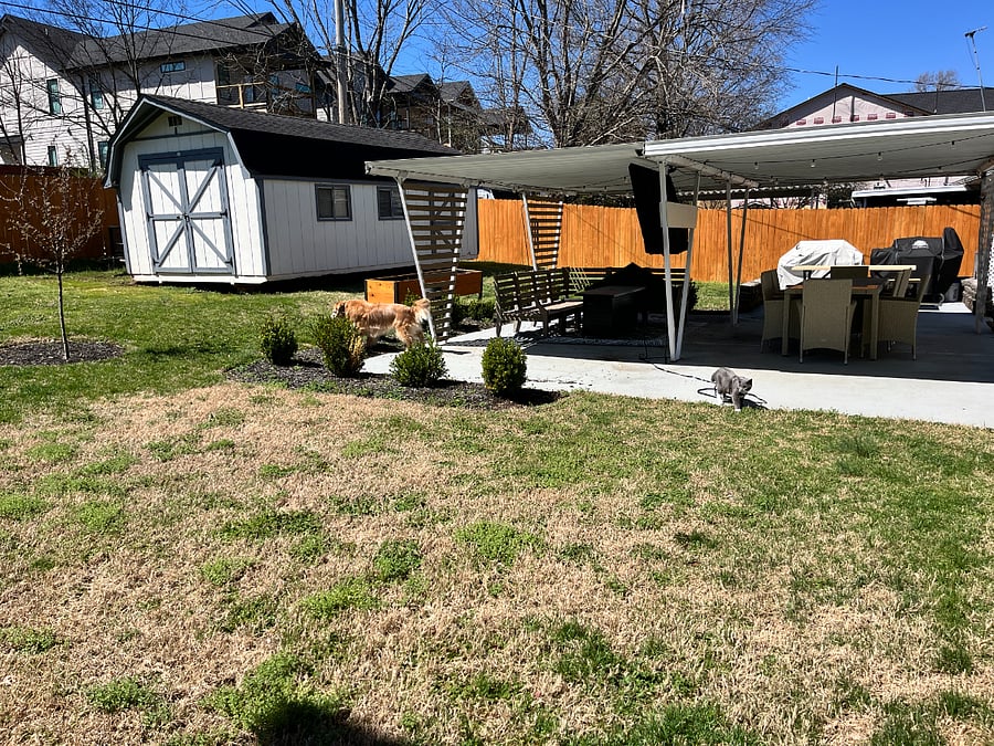 Covered patio with outdoord couch, tv, dining table and grill