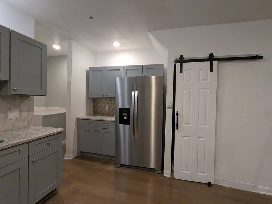 Full size refrigerator and trash/recycling closet.