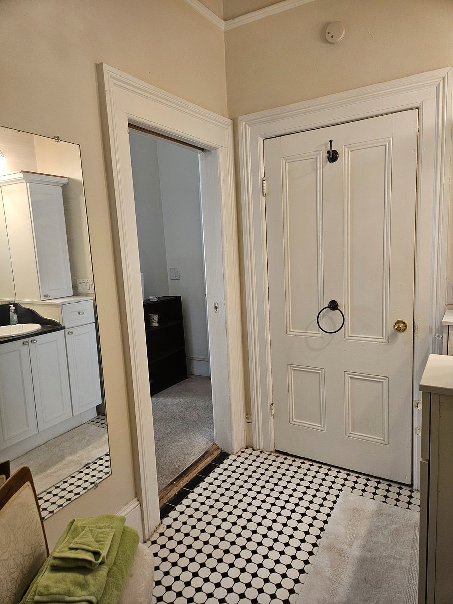 Bathroom has a poceket door, full length mirror.