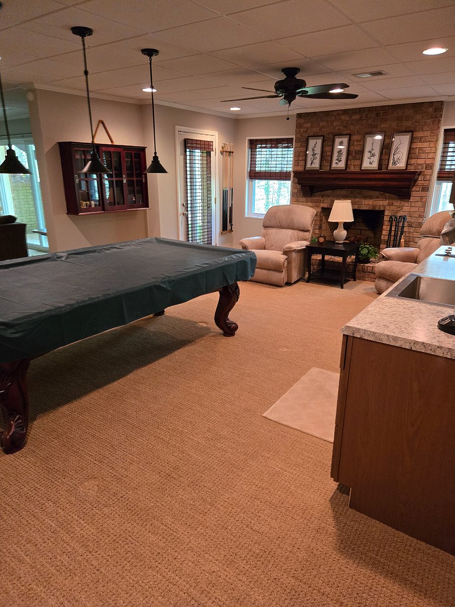 Pool room with exit to patio and stairs leading to driveway
