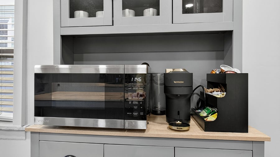 The kitchen includes a microwave with air fryer functionality, a fully stocked Nespresso coffee bar, and an array of teas for added convenience and comfort.