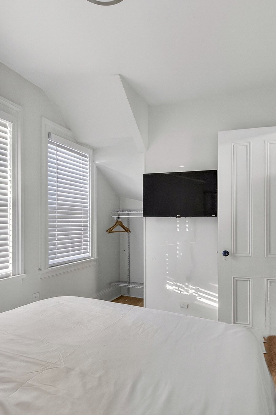 Bedroom 1 includes a Smart TV and a small open-faced closet with hangers and shelves for convenience.
