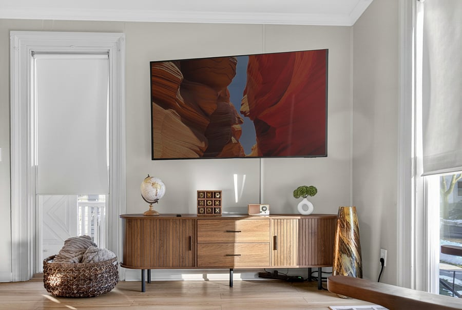 The living room also includes a credenza stocked with board games and a basket of throw blankets, adding a cozy and welcoming touch for guests.