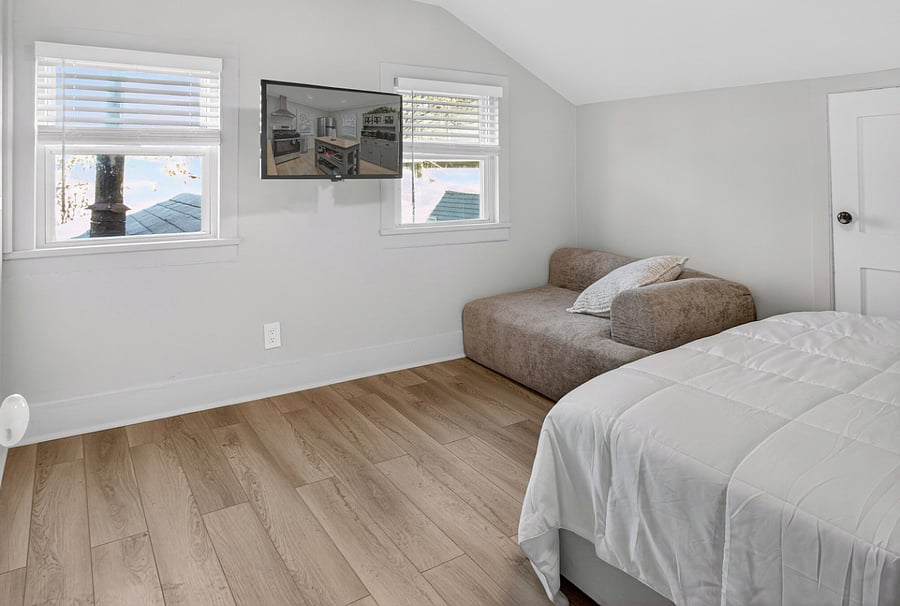 Bedroom 2 features a queen bed with an LED light frame, a side table, a Smart TV, and a cloud modular sofa chair.