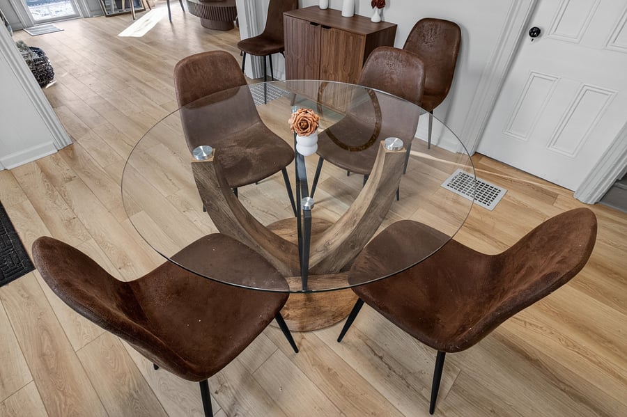 Dining table set for four, with the option to expand to six by adding the two chairs stored against the adjacent wall.