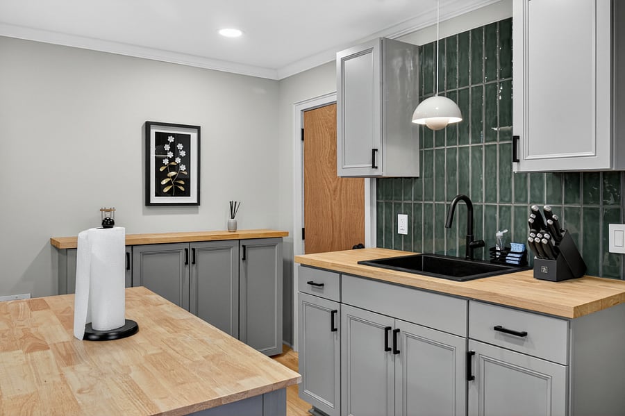 Kitchen view highlighting the sink, pantry storage, and ample cabinetry.