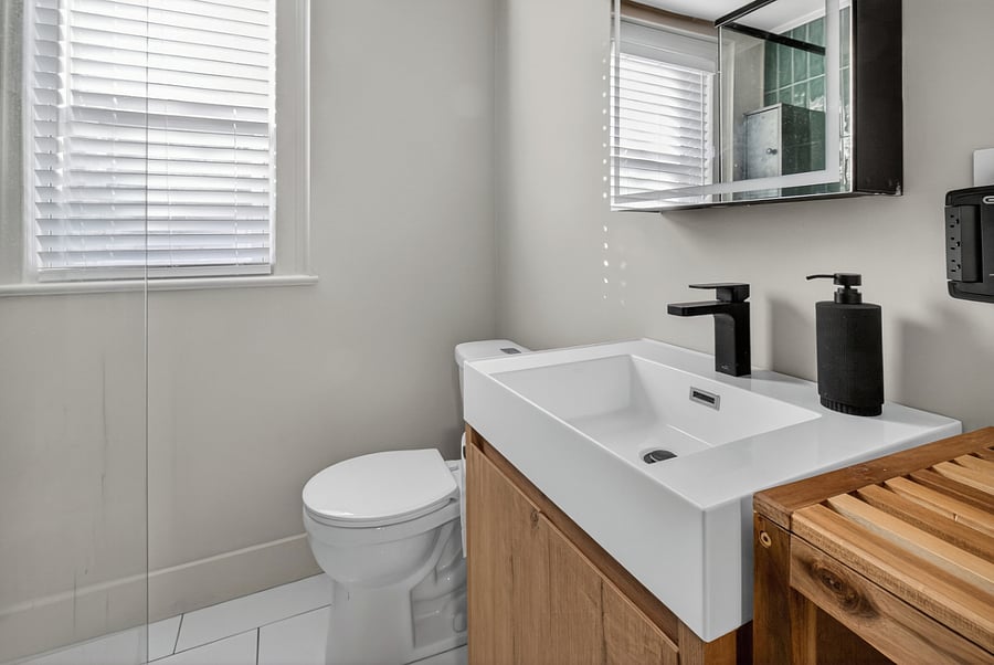 The bathroom features a mirror over the sink with optional LED lighting and defrosting buttons, along with built-in storage for added convenience.