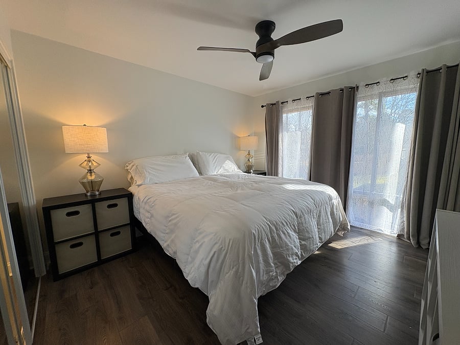 Primary Bedroom with adjustable King size bed, MCM floor to ceiling original windows allowing natural sunlight indoors.