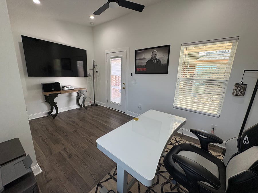 Exterior private office with 75 inch TV, video game console, heated and cooled, adjustable desk, WiFi and storage space.