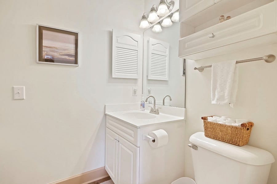 The second bathroom has a vanity and wall cabinet for extra storage.